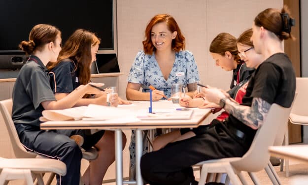 ABCN mentors seated at a table with students